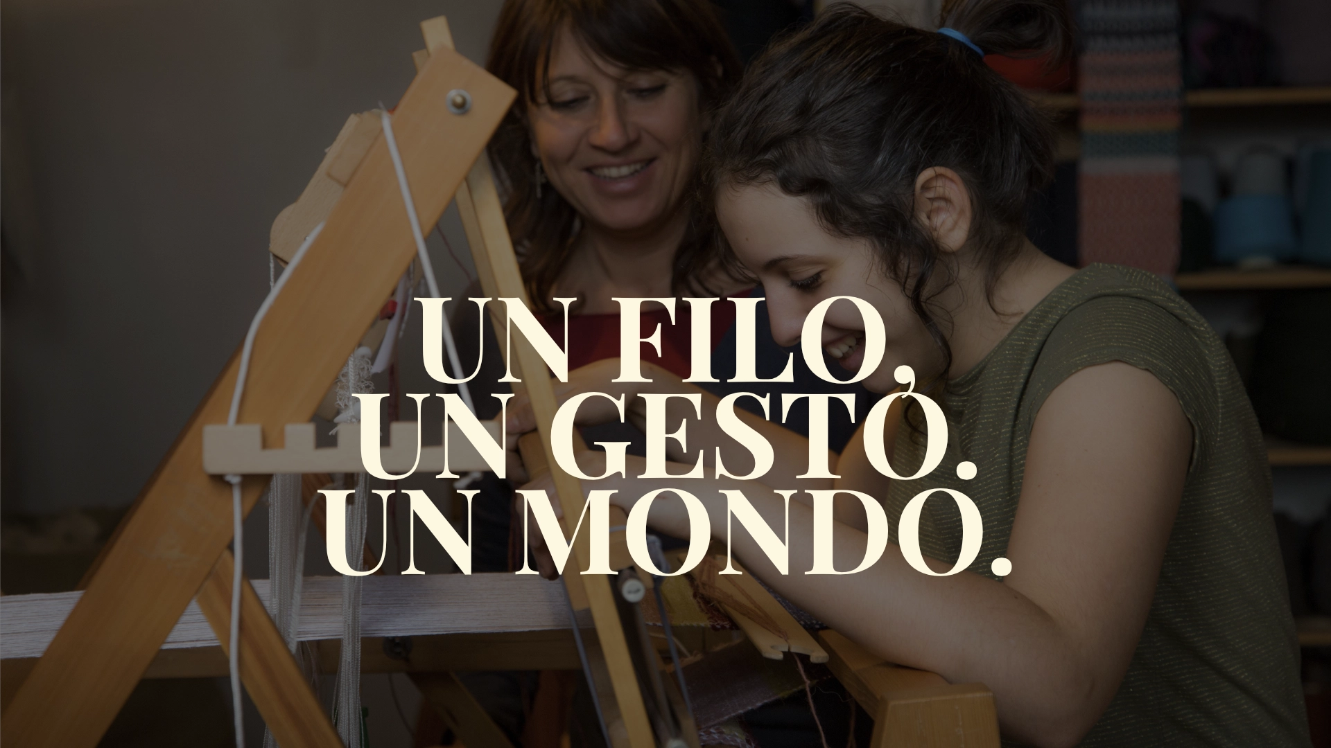 Una donna che aiuta una bambina a usare il telaio con in sovraimpressione la scritta Un filo un gesto un mondo
