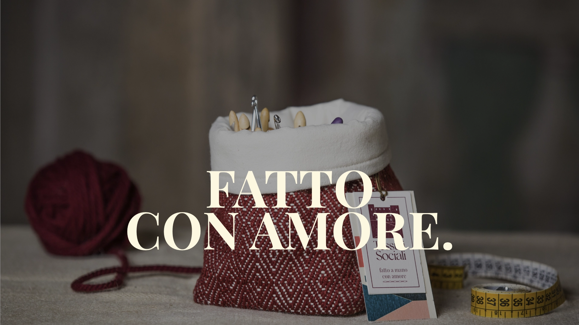Foto di un sacchetto con uncinetti realizzato da tessuti sociali con la scritta fatto con amore