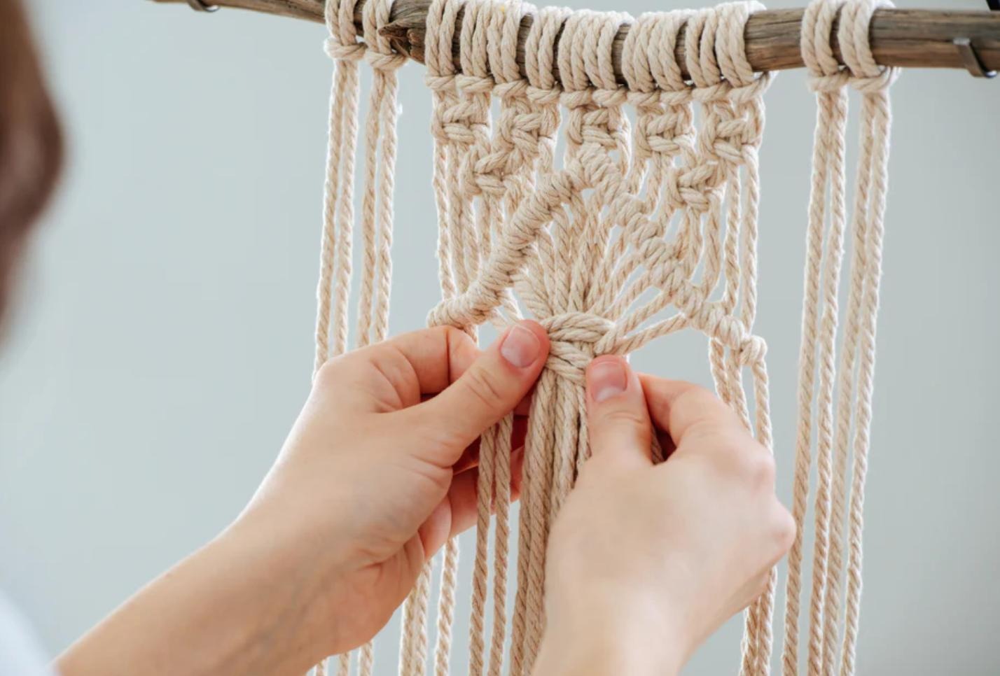 Foto di una donna che usa strumenti di tessitura tradizionali